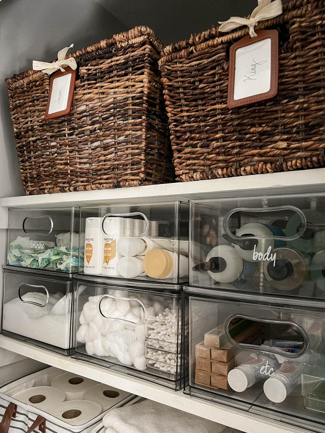 pair of baskets storing sheets on linen closet shelving