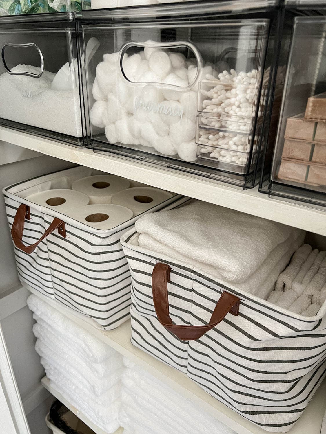 bins storing towels, toilet paper, and toiletries