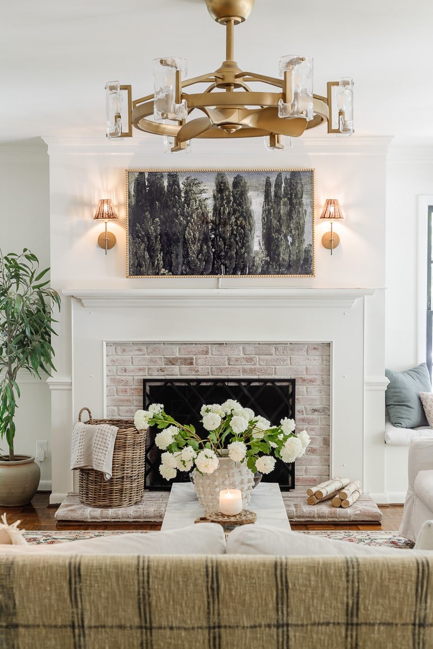 DIY bobbin frame on a Samsung frame TV + rattan sconces above a limewashed brick fireplace