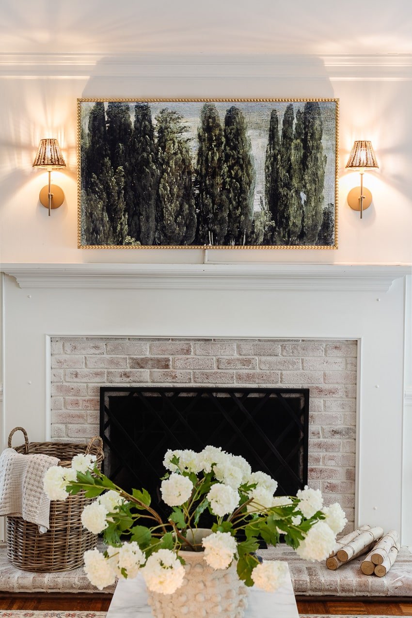 DIY bobbin frame on a Samsung frame TV + rattan sconces above a fireplace
