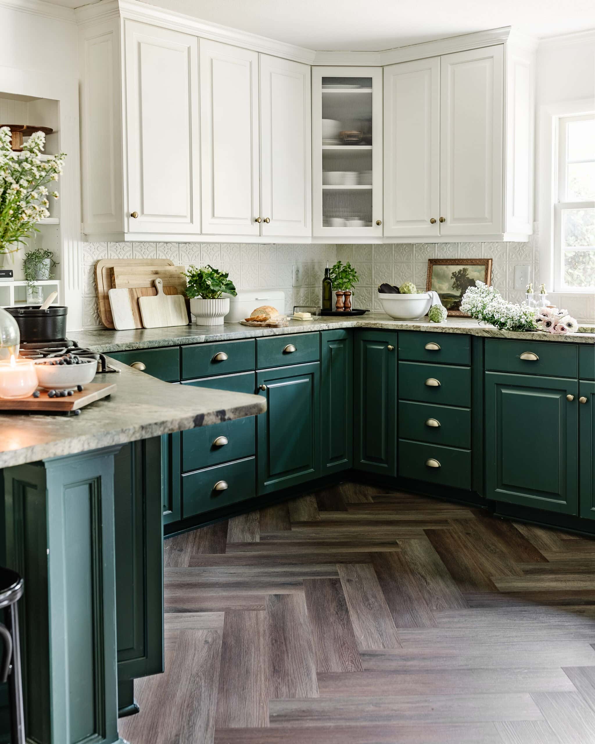 green and white kitchen cabinets with herringbone floors