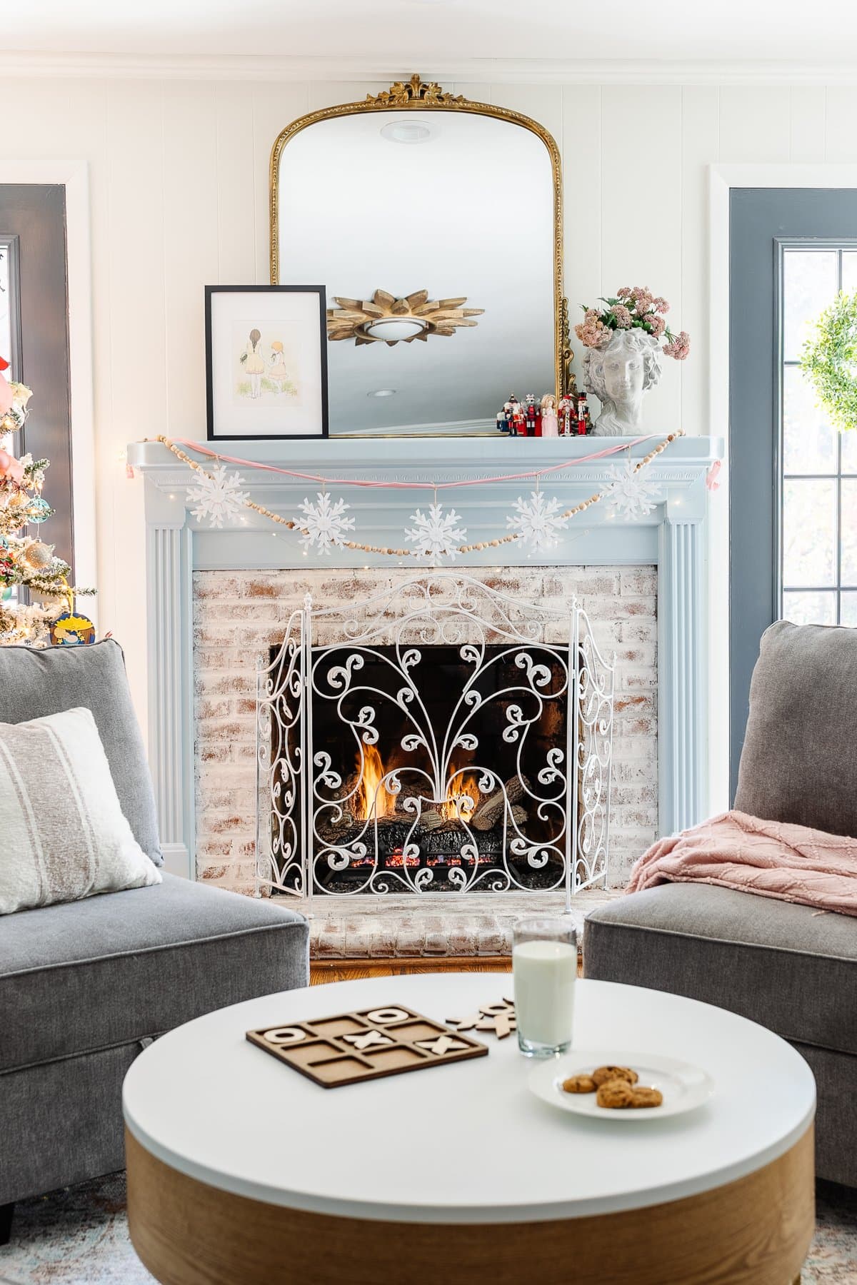 snowflake ornaments strung onto ribbon to make DIY garland on a mantel