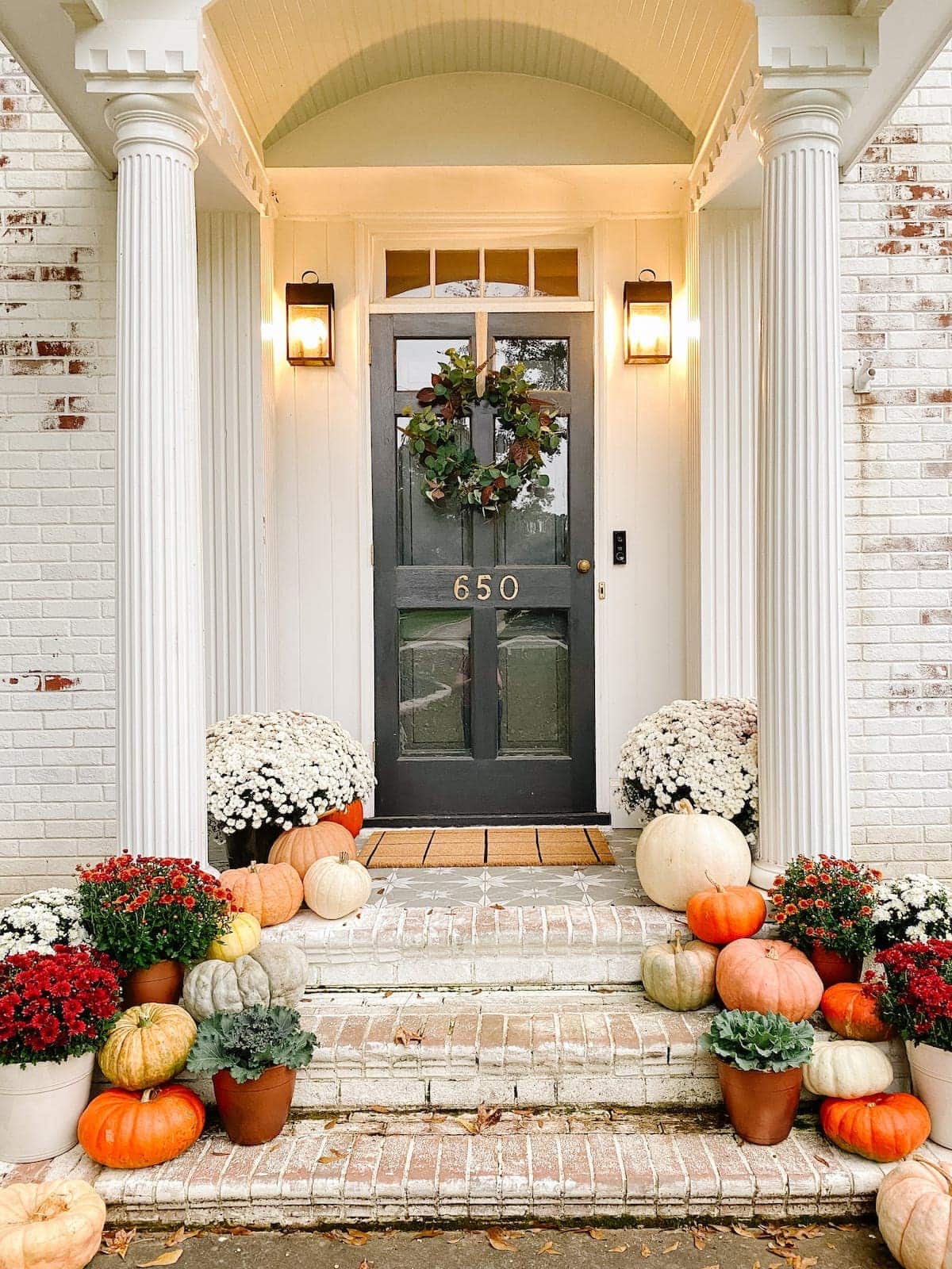 Colorful Fall Porch Stoop Decorated with Mums and Pumpkins with Limewashed Brick