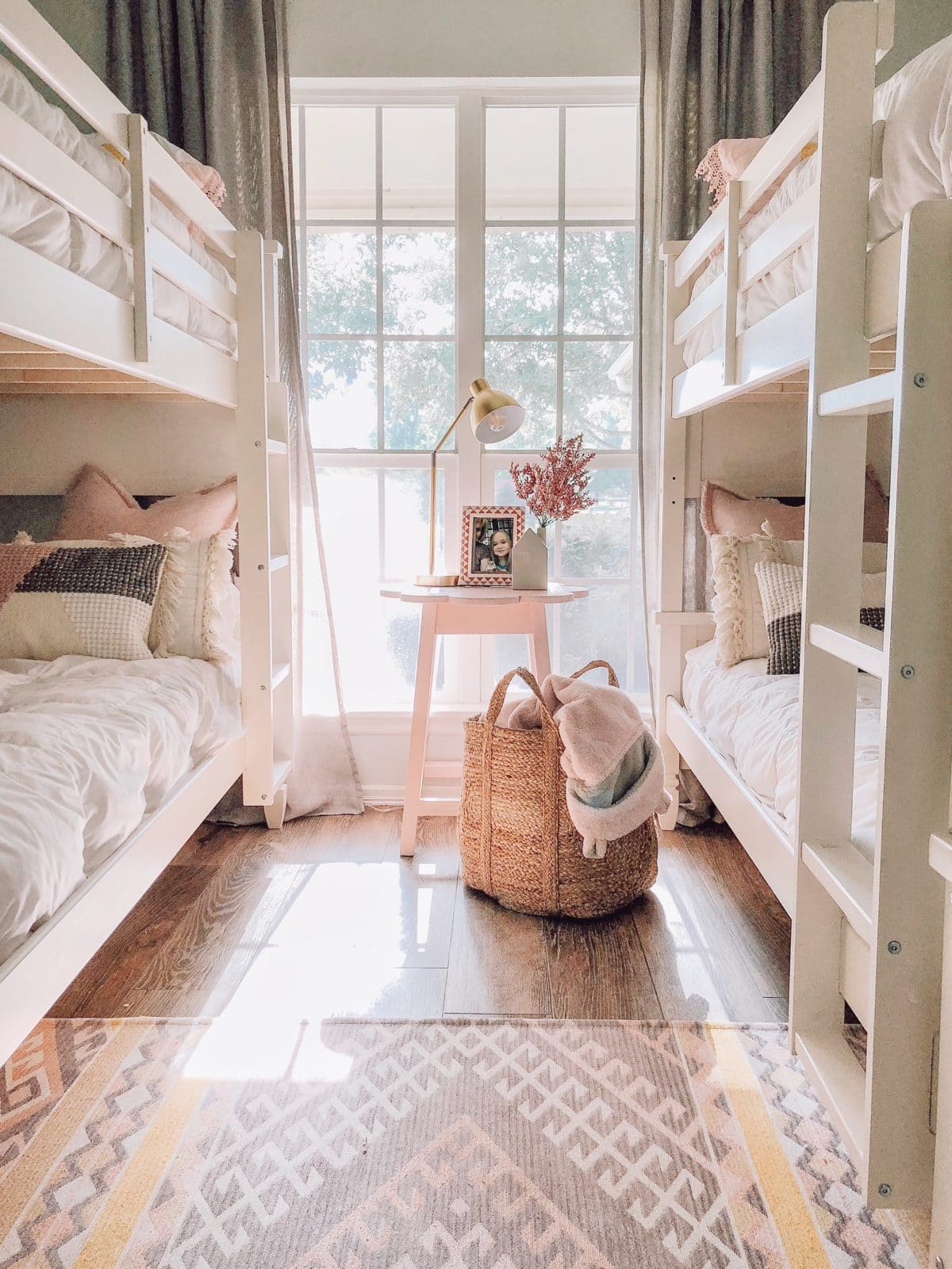 two bunk beds framing a window for a 4 person shared bedroom