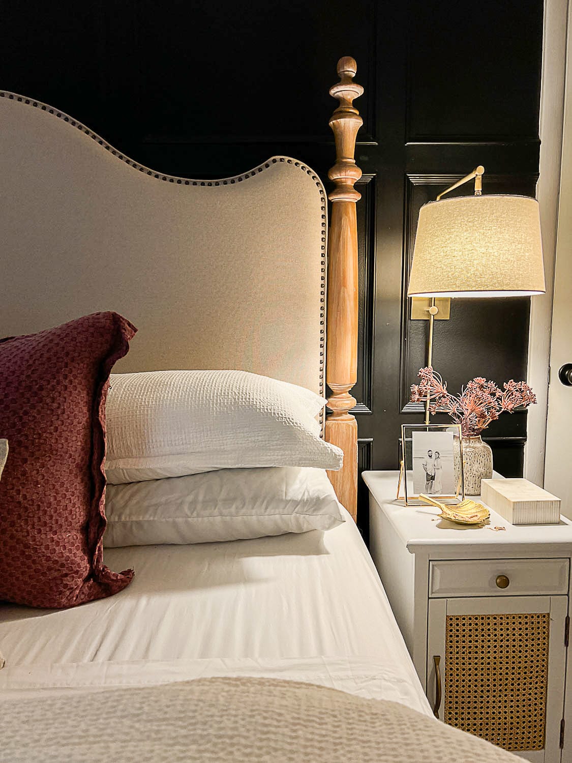 cozy bedroom lighting, bedding, and nightstand with decor