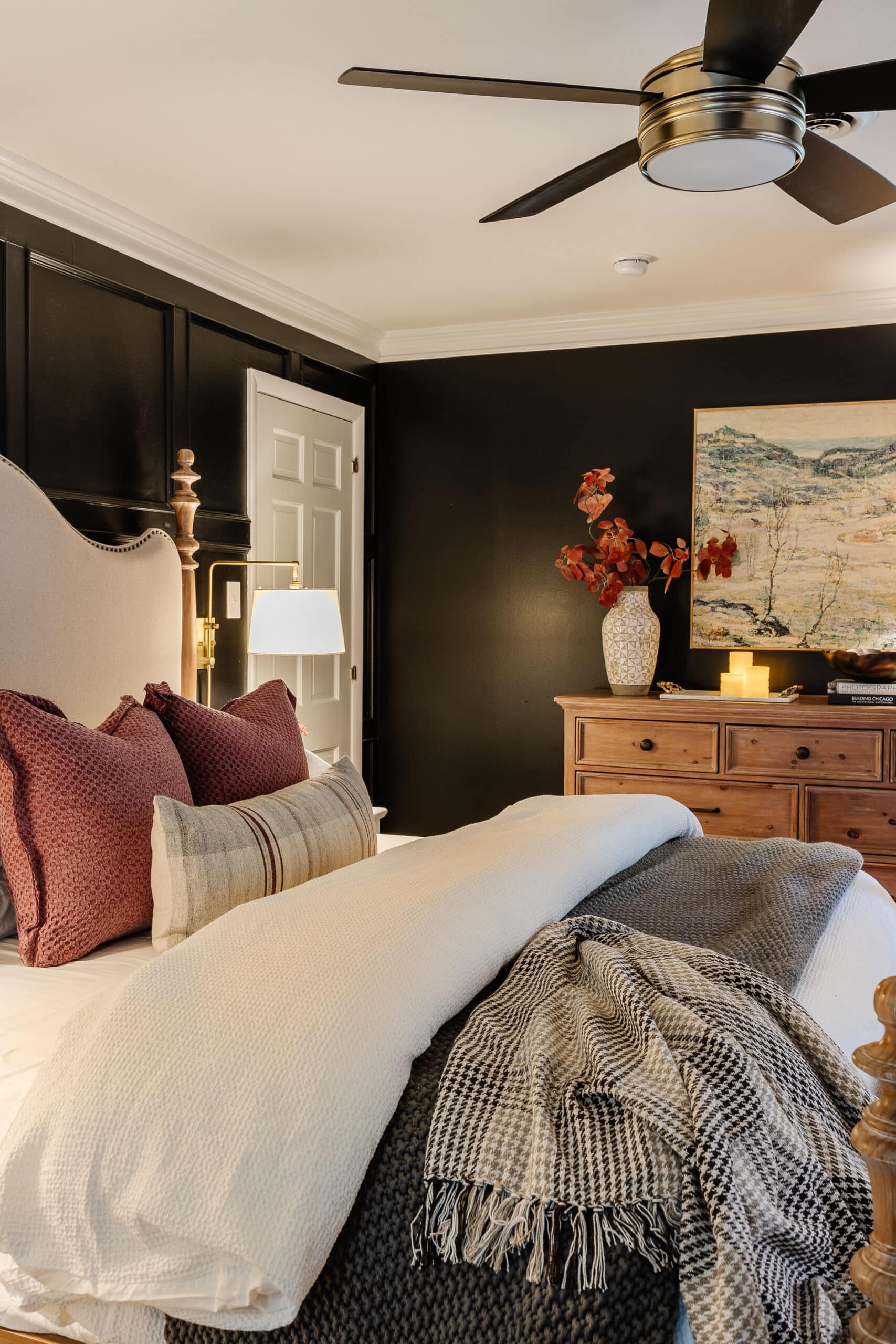 cozy bedroom with lamps, candles, art, and fall decor