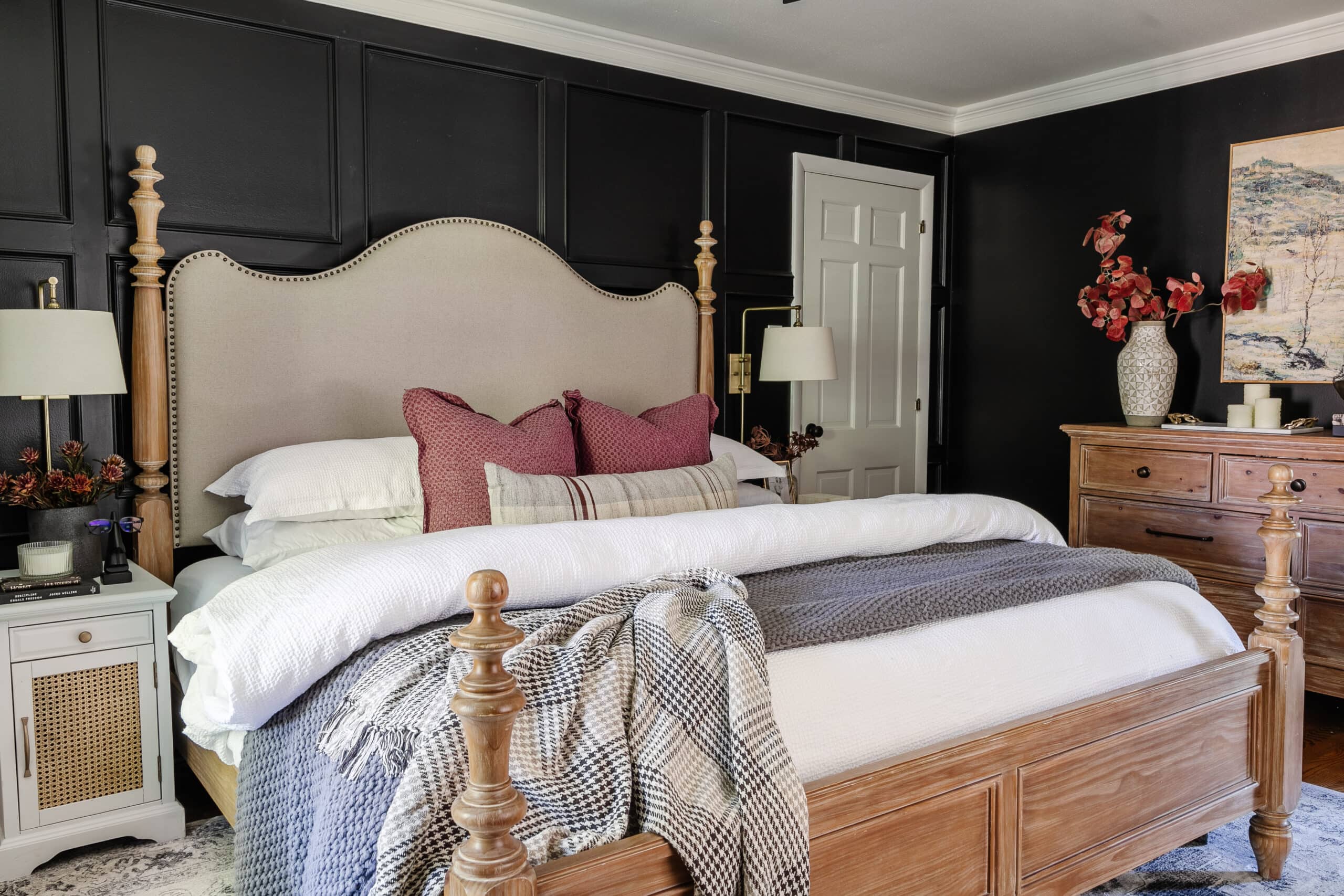 bedroom with black walls, wooden bed and dresser, and comfy bedding