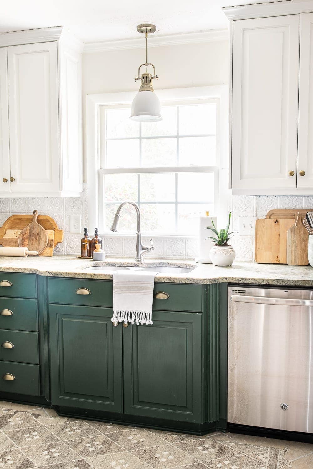 white pressed tin backsplash in a kitchen with white and green cabinets