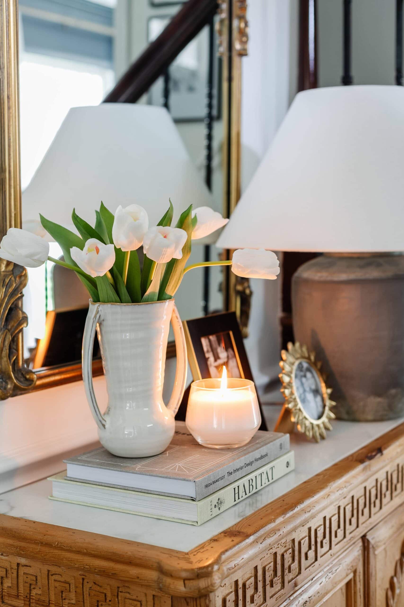 fake tulips on a tabletop with books and candle 