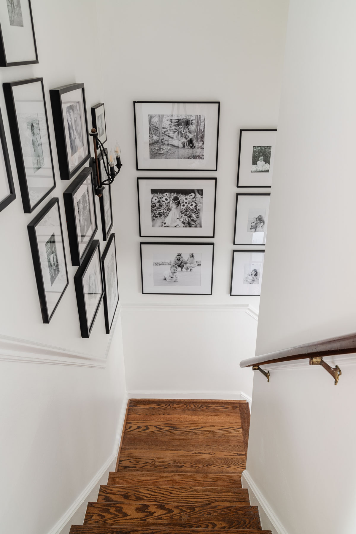 how to make your house look expensive - mat your photos - family photo gallery wall in black frames on a staircase