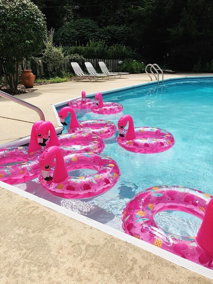 flamingo themed pool party using flamingo pool floats as decor and party favors