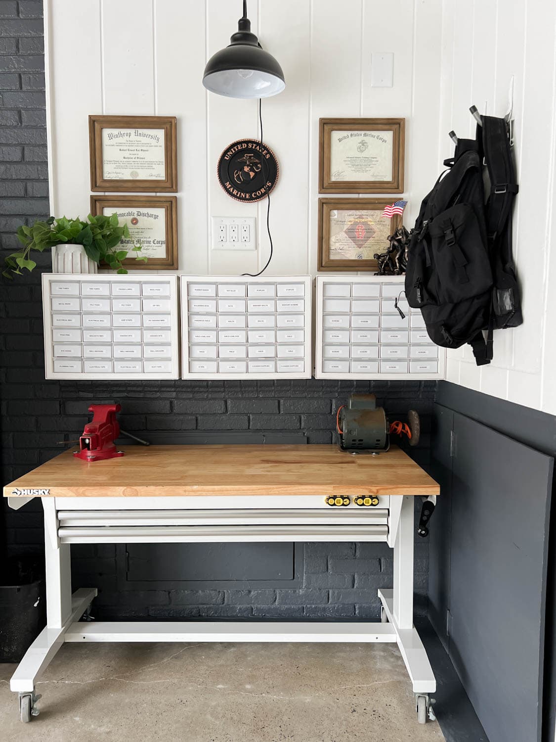 rolling workbench under hardware organizers in a garage