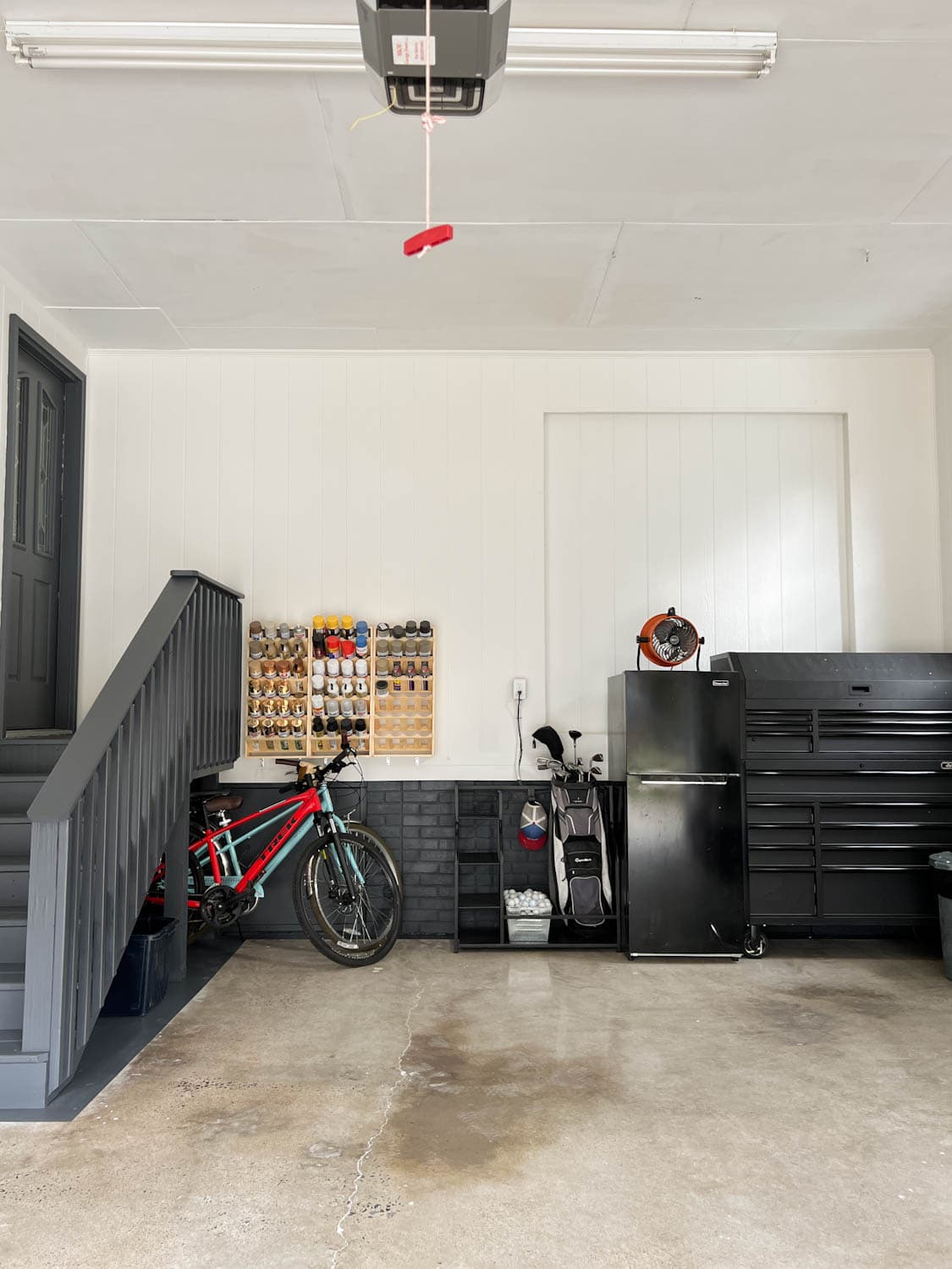 garage after with white walls and black trim and repurposed concrete floor