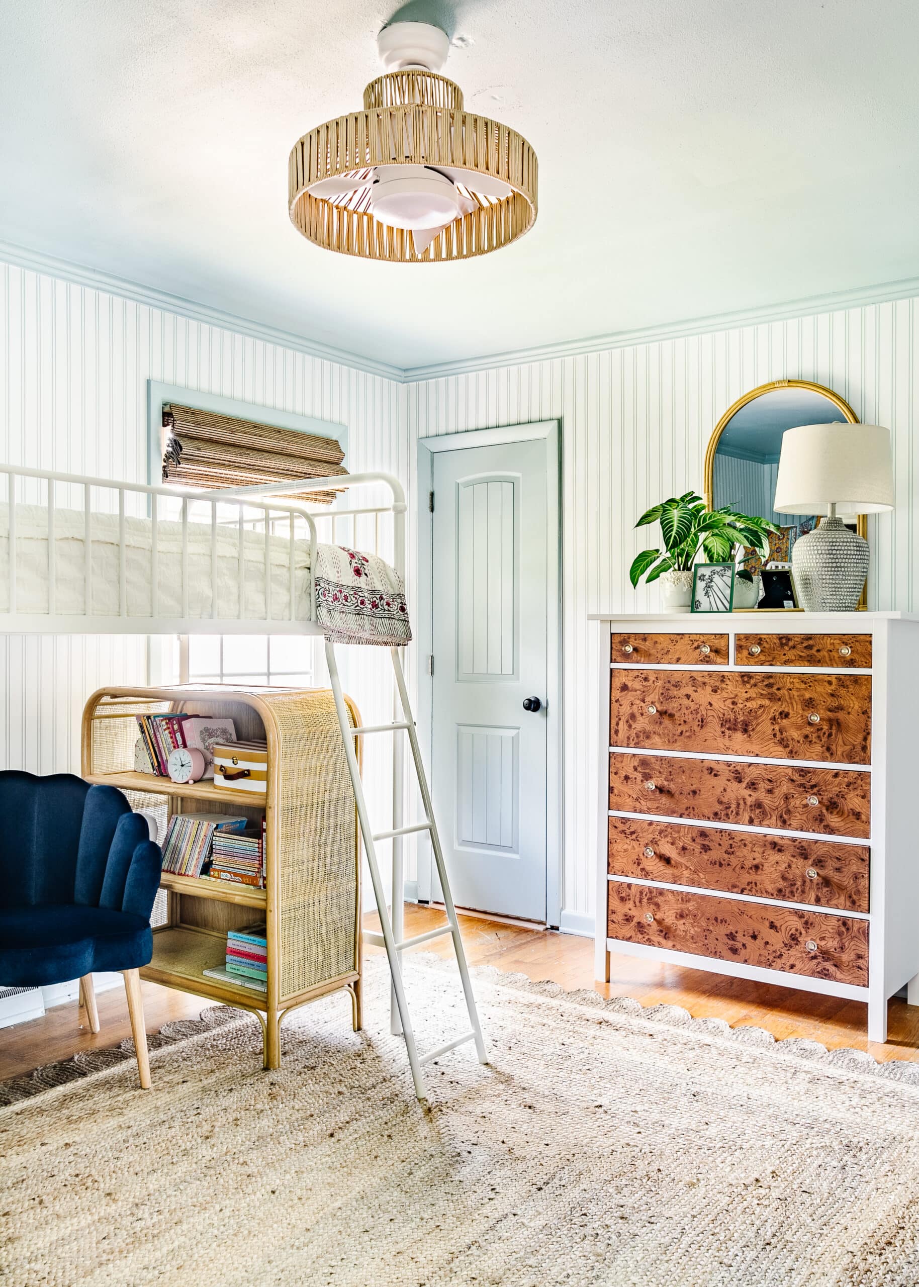 little girl's bunk room with jute rug, burl dresser, and striped walls