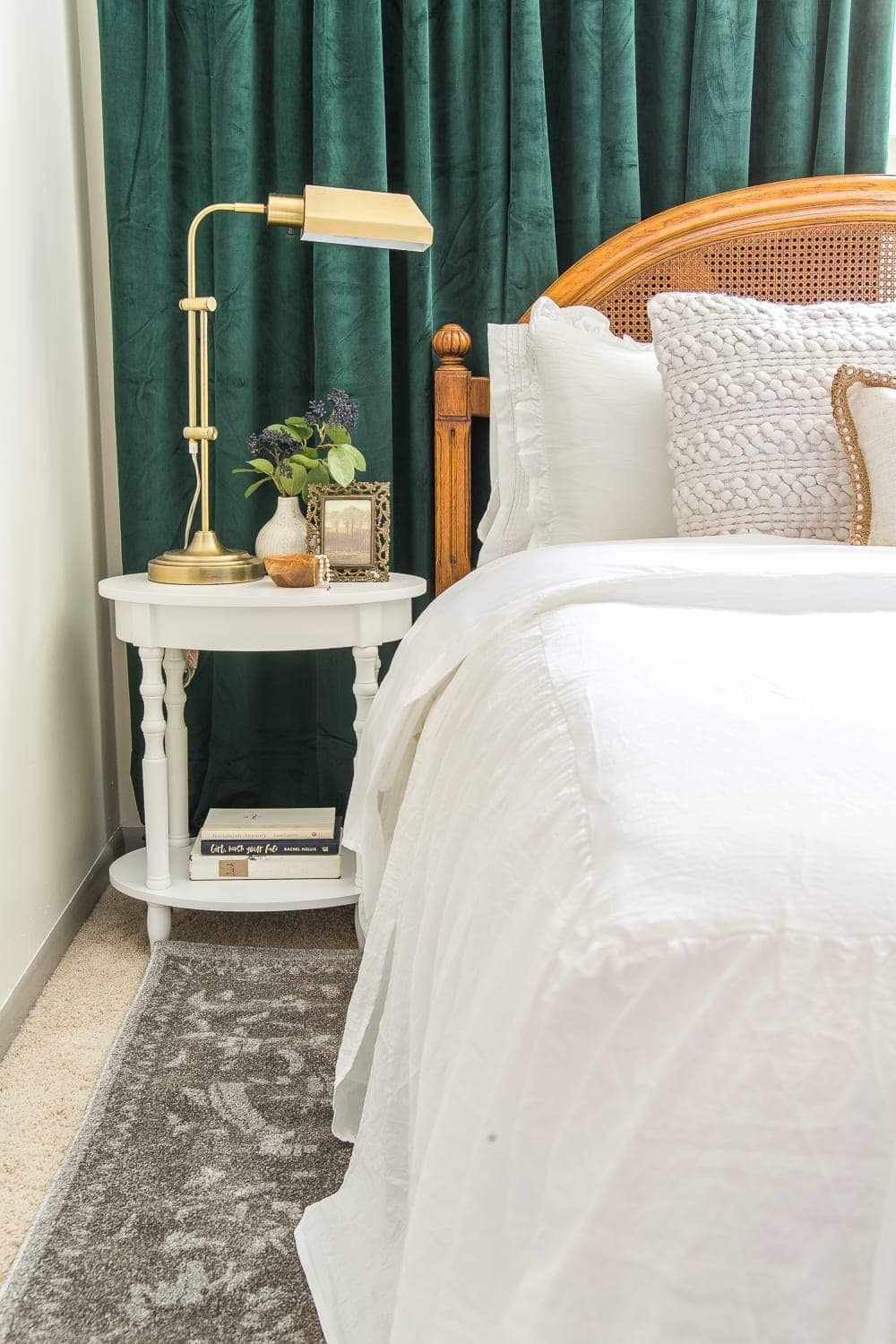 white bedding and green curtains in a guest bedroom