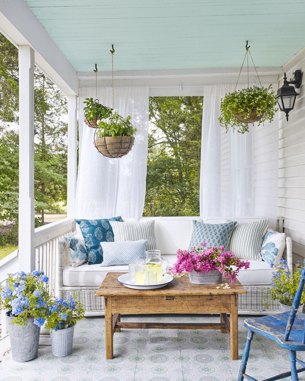 country porch with hanging baskets and blue painted ceiling