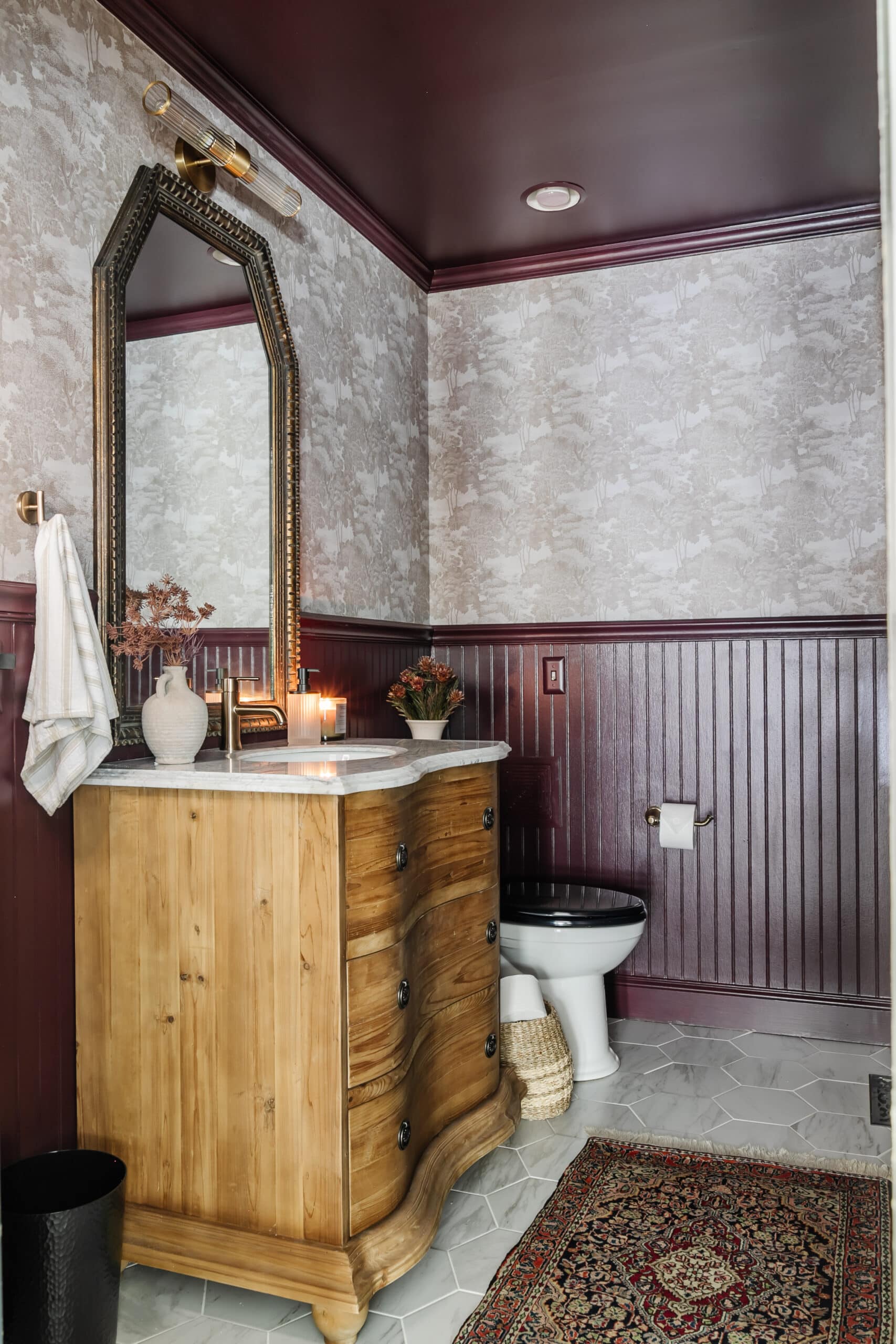 windowless small powder room with vintage dresser vanity  and marble hexagon floors