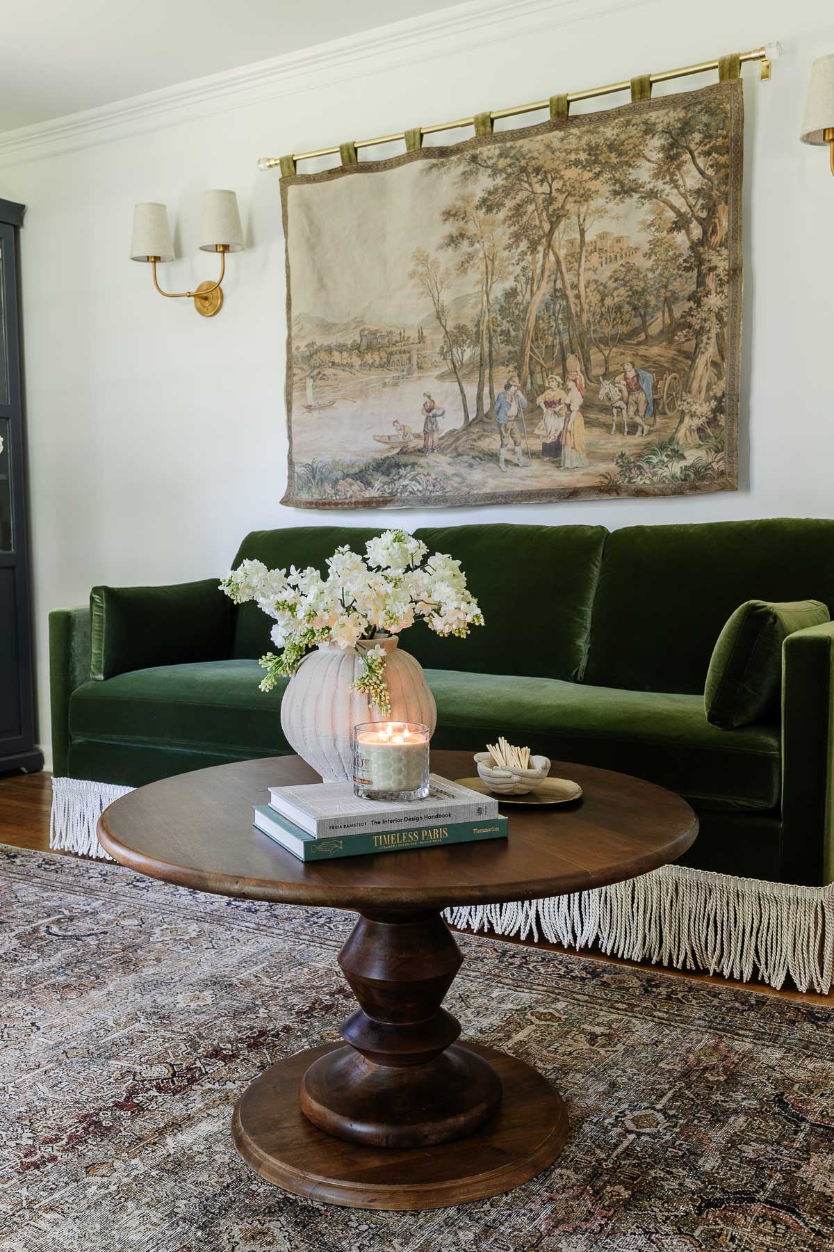 fringe trim added to a sofa with styled coffee table and tapestry in an office