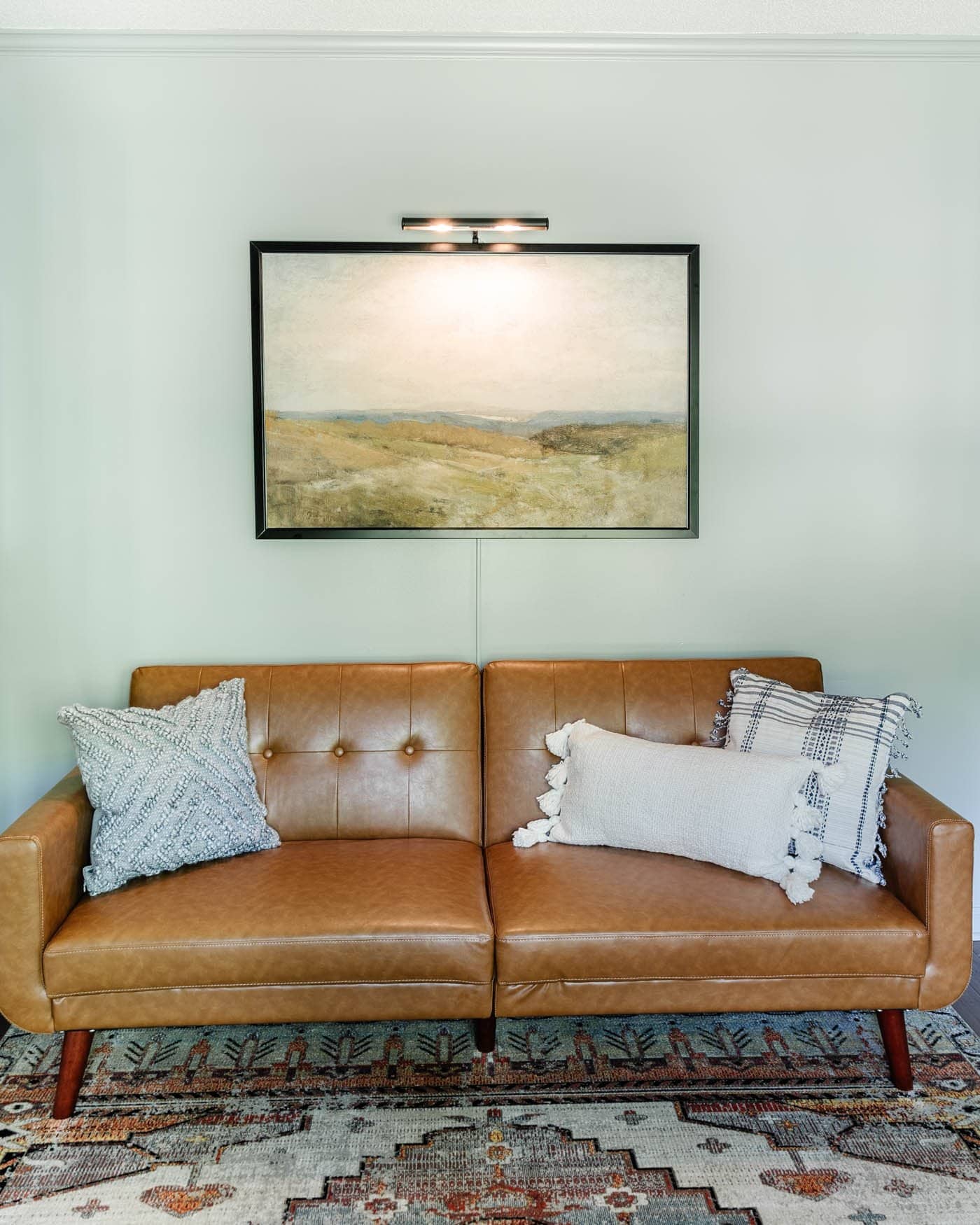 office lounge with a faux leather futon, art, and picture light