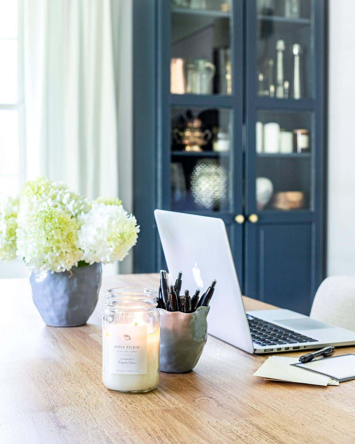 laptop on a desk in an office with a cabinet painted Benjamin Moore Hale Navy