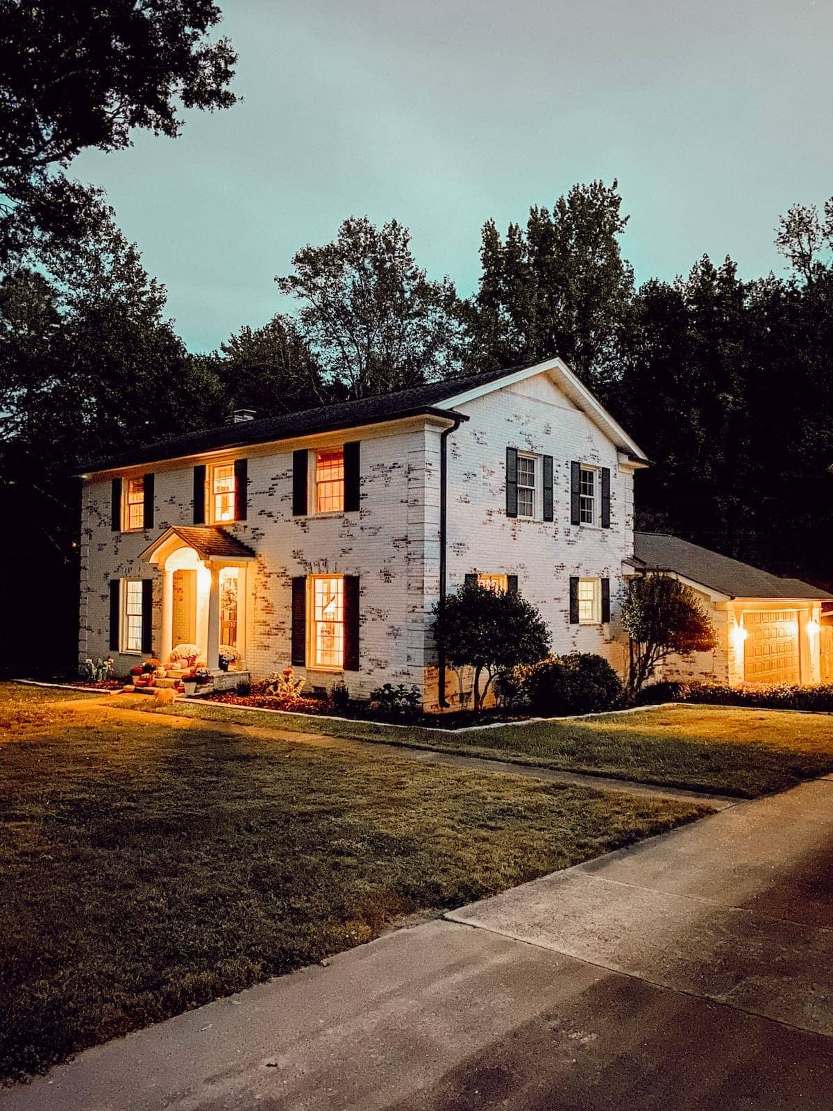 limewashed brick colonial house at night