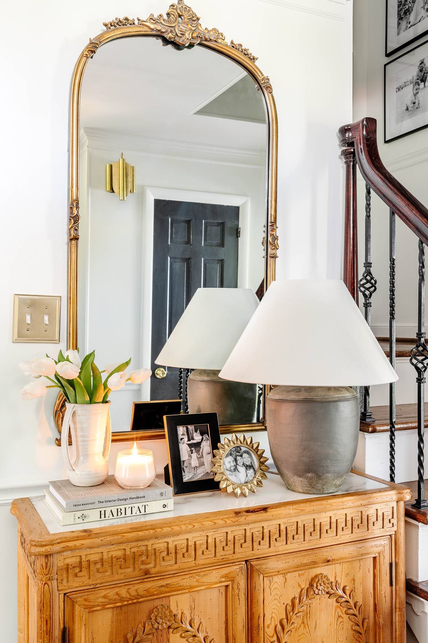 antique gold mirror in an entryway above foyer chest