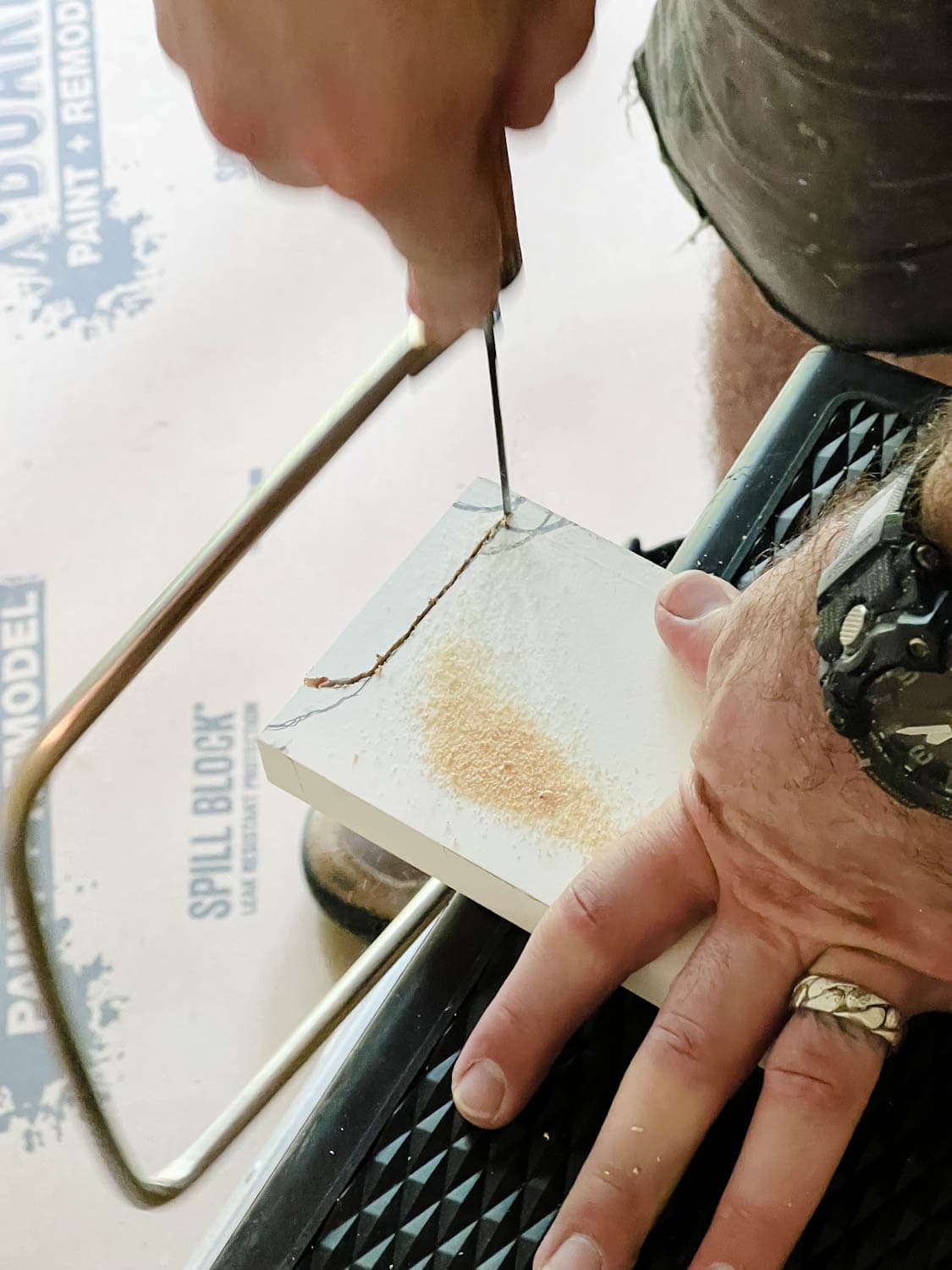 using a coping saw to cut out the shape of a baseboard to meet against a 1x4 board