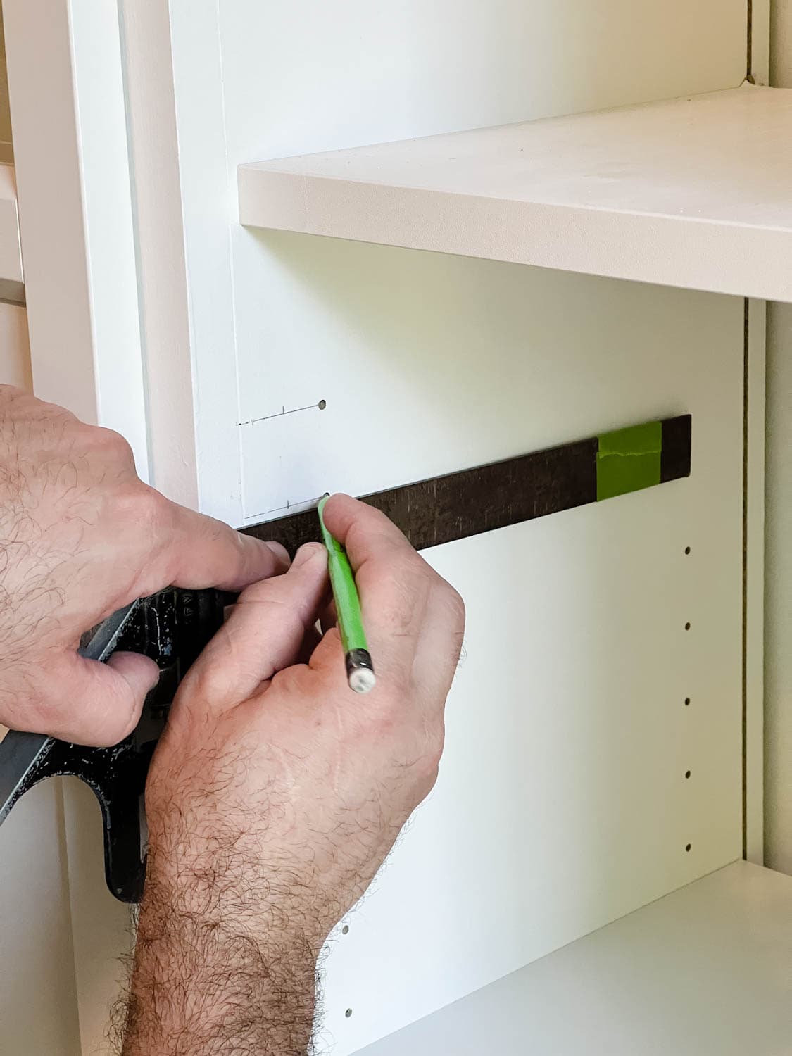 marking new holes to drill for door hinges on shelves