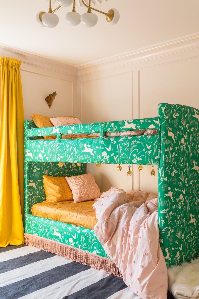 DIY upholstered bunk bed idea with blush pink walls and yellow curtains