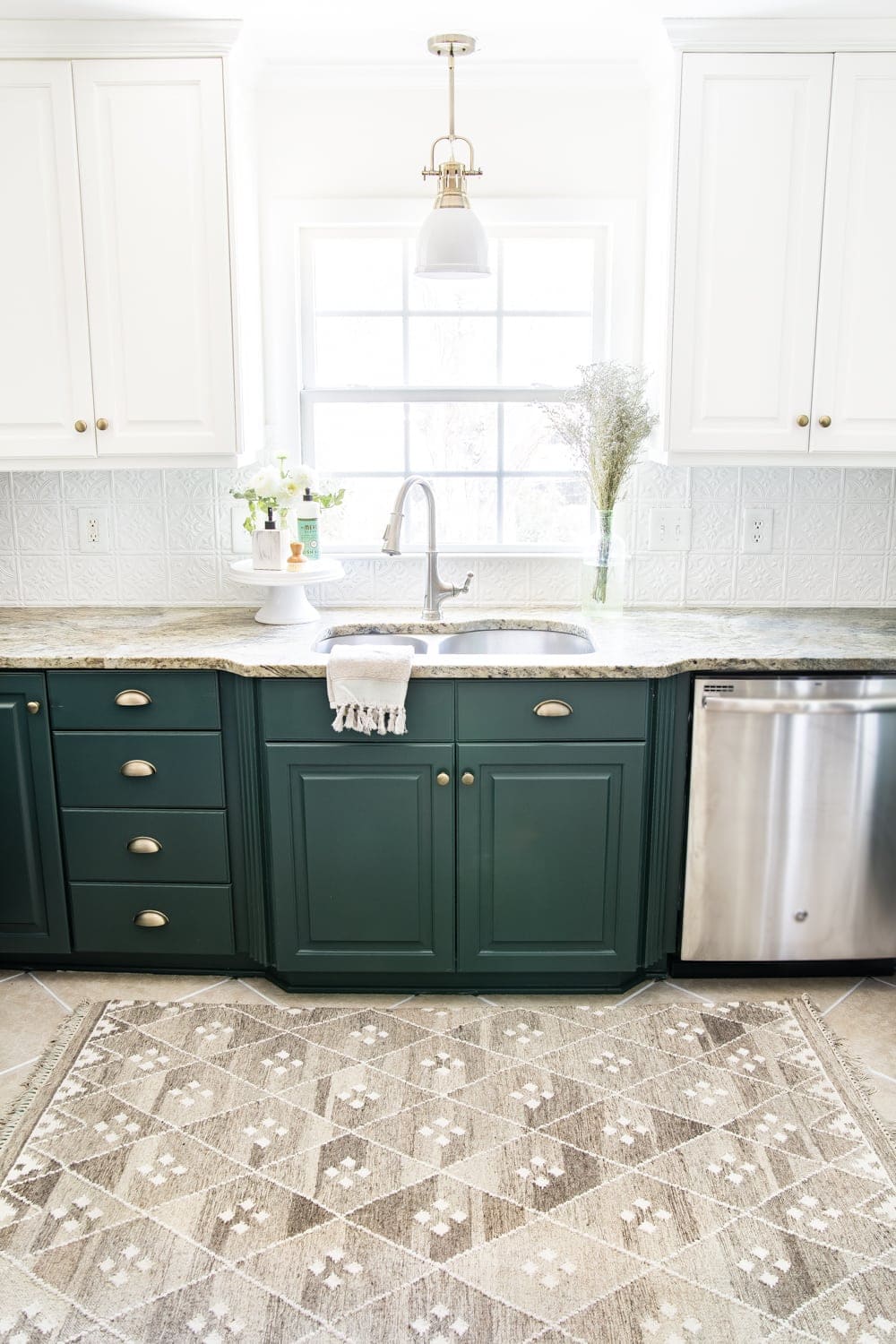 small kitchen with green lower cabinets, white upper cabinets, and white pressed tin backsplash