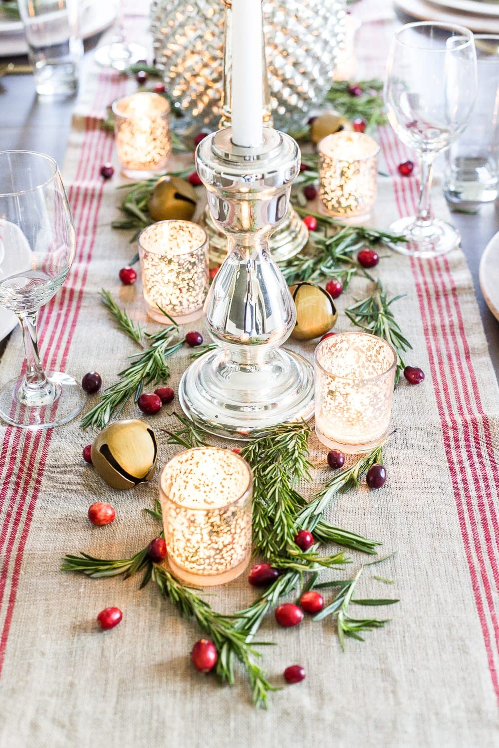 scattering rosemary and cranberries on a holiday centerpiece