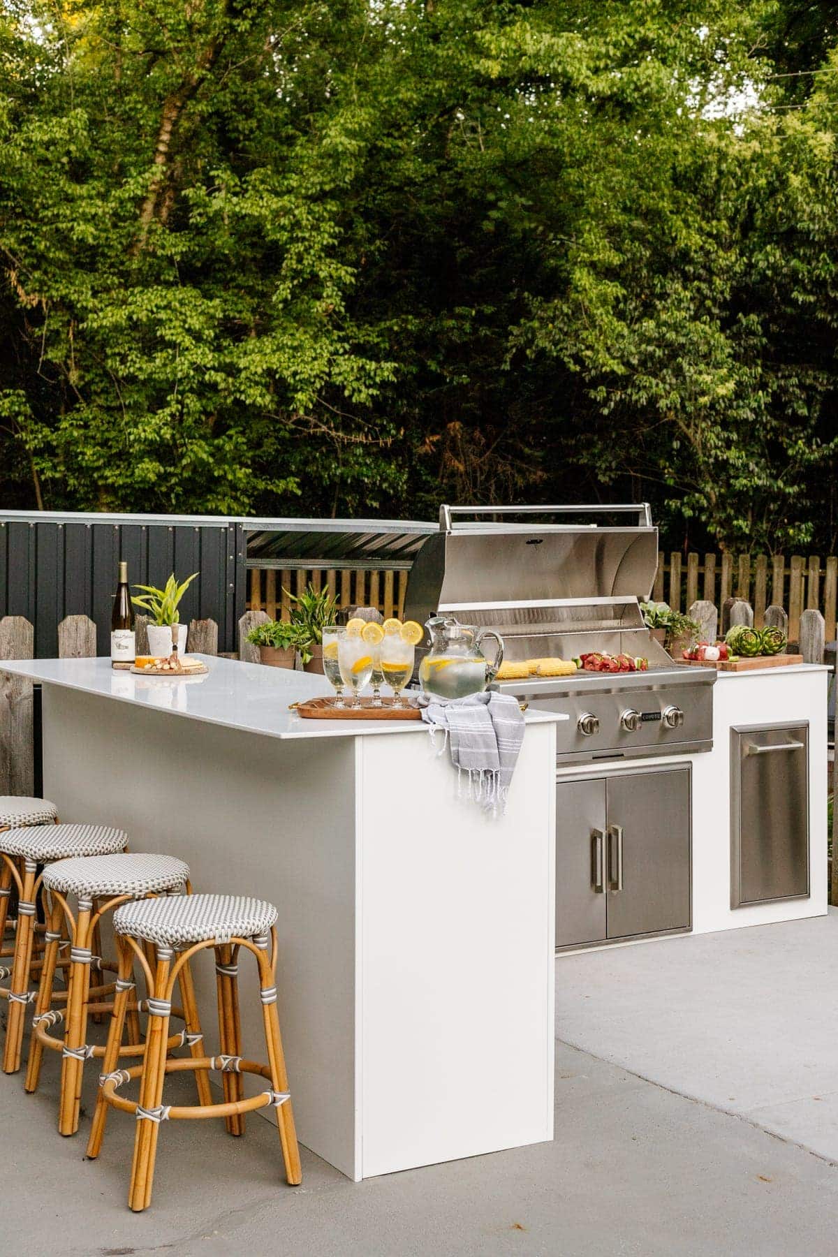 white modular outdoor kitchen with french bistro stools