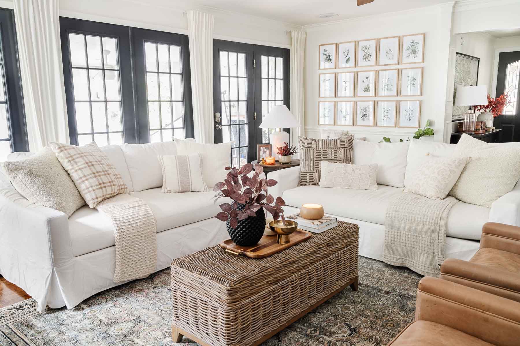 pottery barn sofas in living room with white walls and black windows