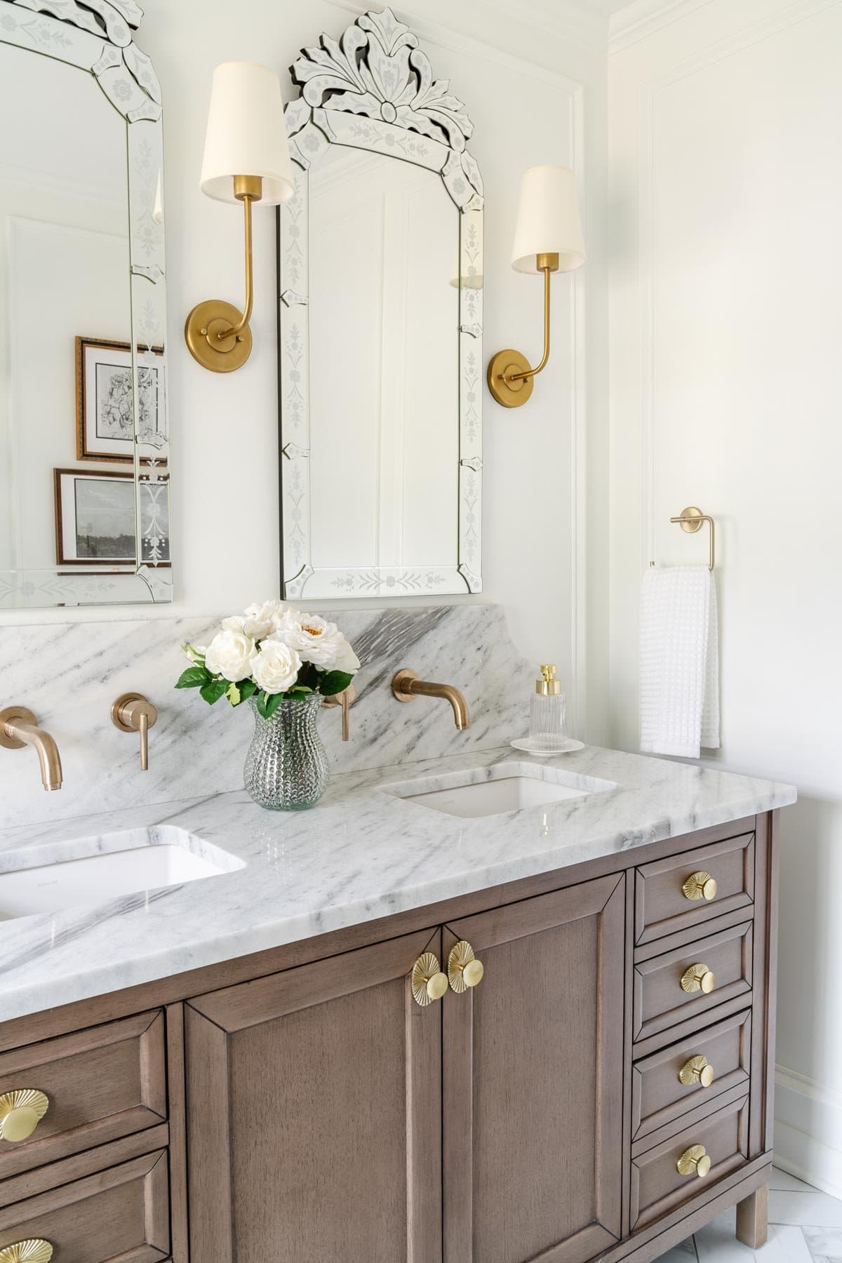 marble bathroom countertop with wood vanity and Venetian mirrors