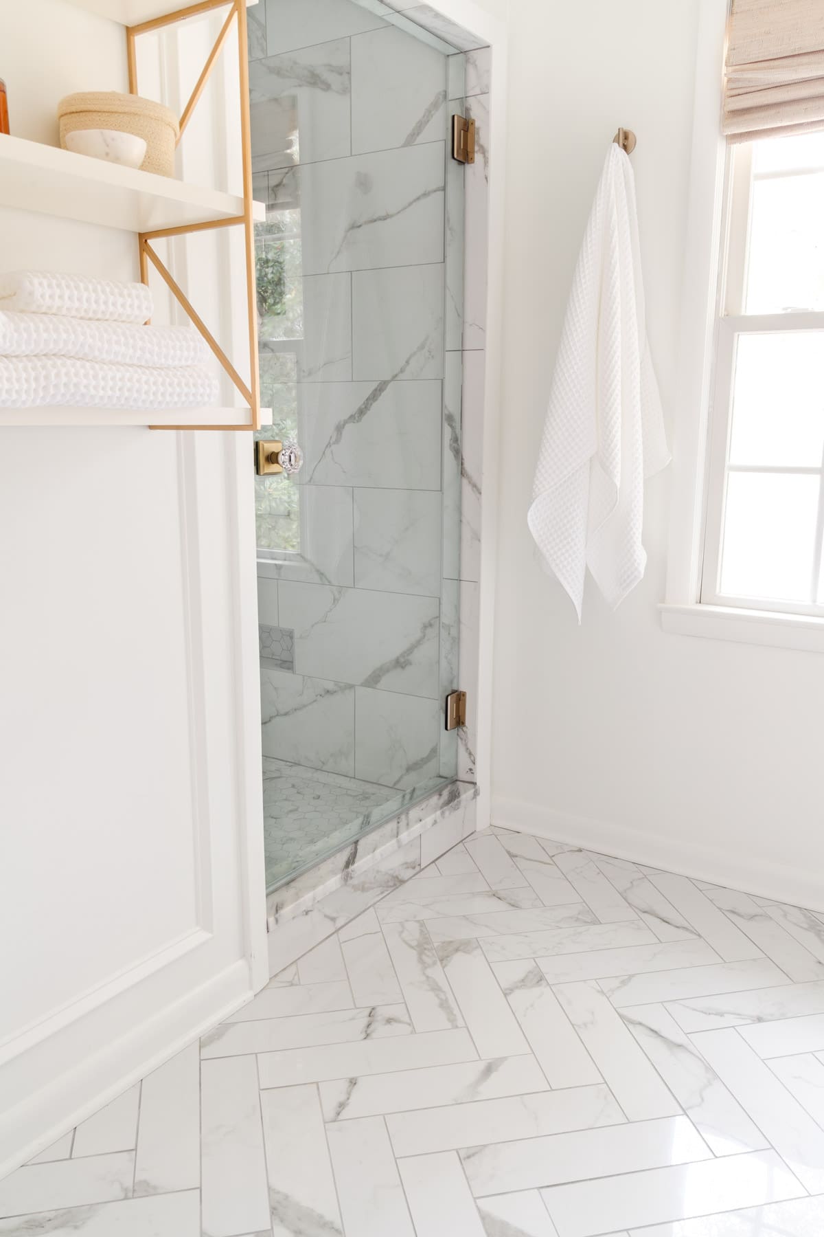 herringbone tile floors in a white bathroom