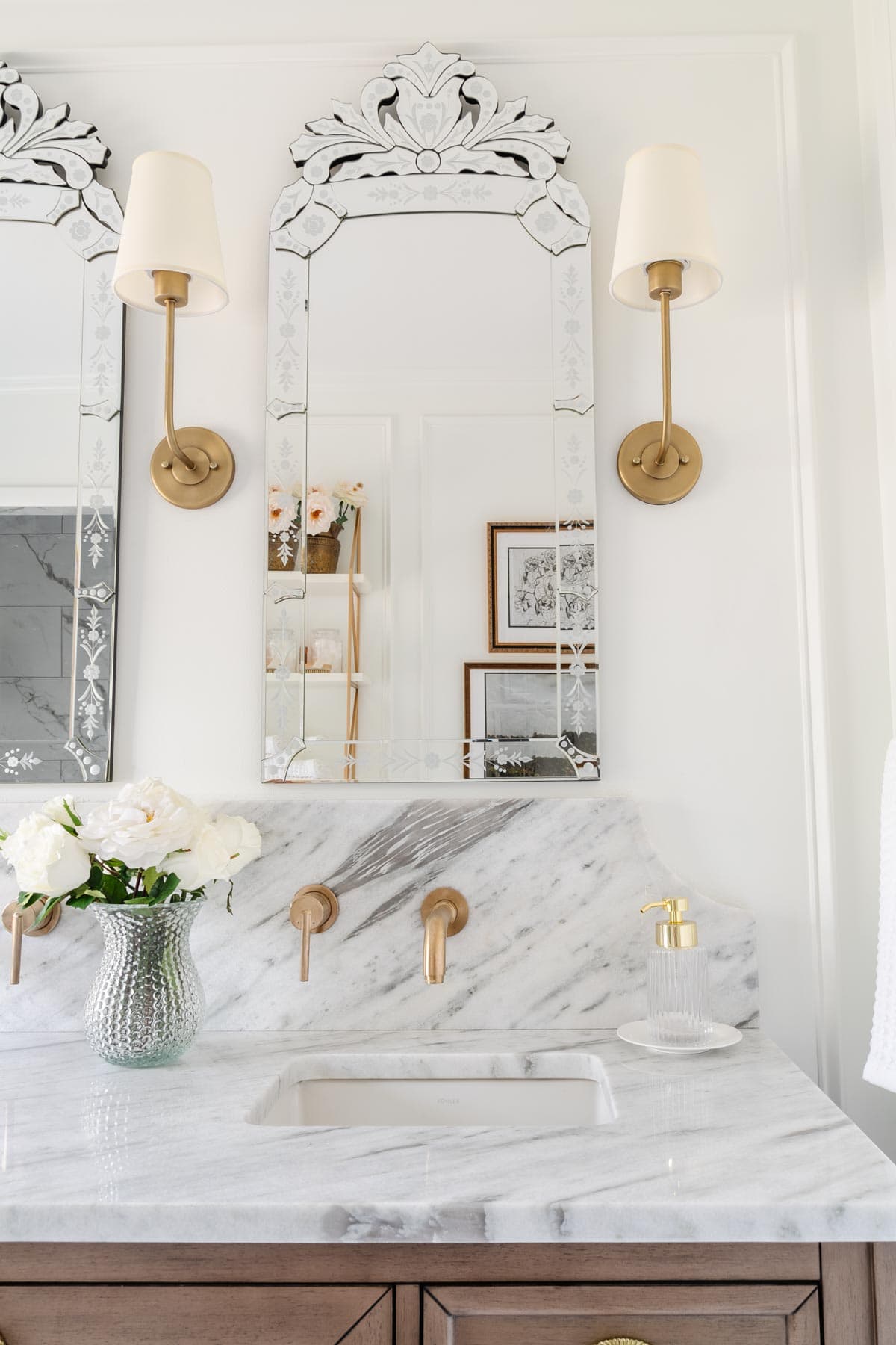 marble bathroom countertop with scalloped backsplash and venetian mirrors