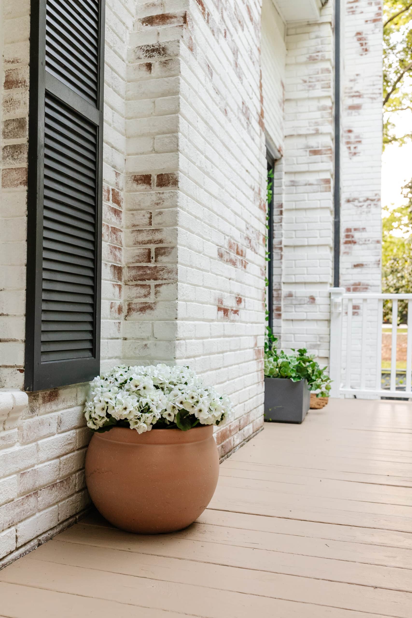 side porch makeover with terracotta planter of faux flowers