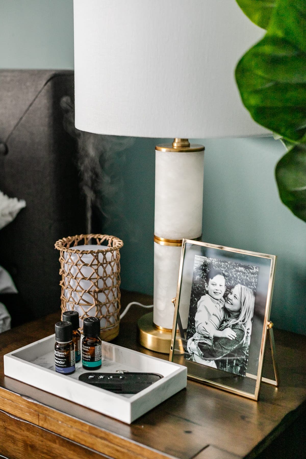 how to make your house look expensive - be mindful of your home's scent - diffuser on a nightstand with nightstand decor