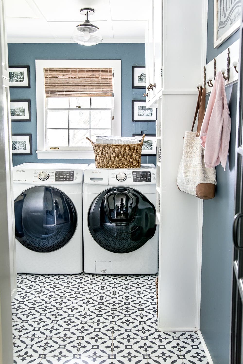 laundry room with medium blue walls and black and white peel and stick tiles