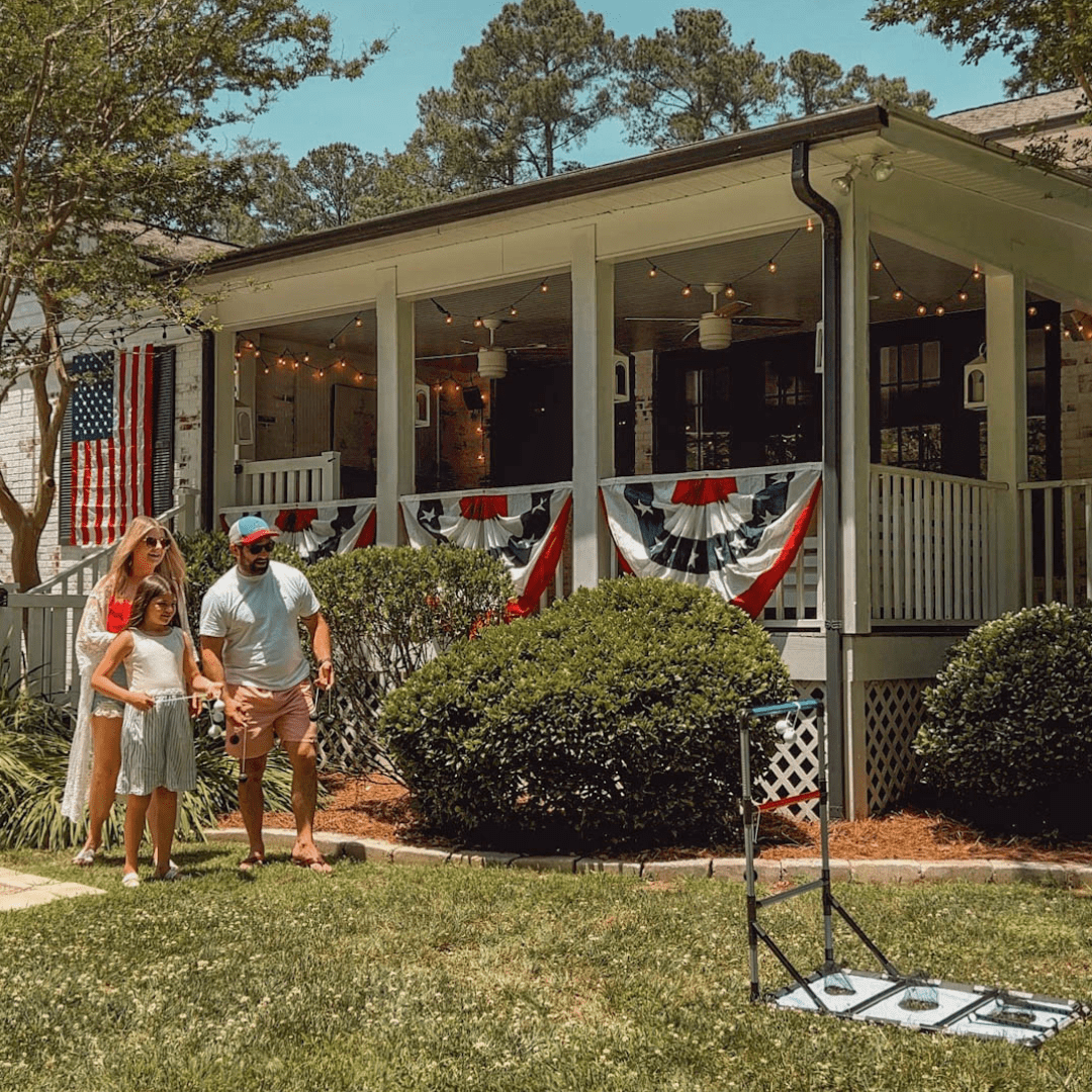 family playing lawn games in the backyard with July 4th decor